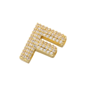 Detailed close-up of a gold-plated letter F pendant with pave-set sparkling zircon stones