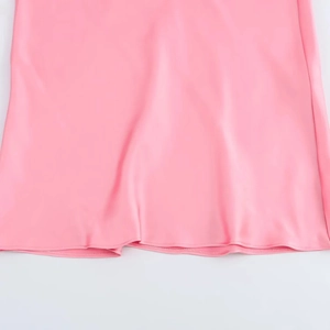 Robe en satin rose montrant les détails de couture et la texture soyeuse du tissu