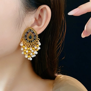 Détail de boucles d'oreilles vintage goutte avec émail coloré et pompons perles