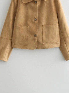 Detail view of camel suede short jacket featuring round buttons and symmetrical large pockets