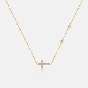 Detailed macro shot of 18K gold cross necklace featuring small zircon stone accents