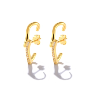 Close-up of S925 sterling silver stamp on golden half-moon pearl earrings with crystals