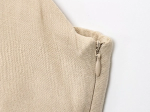 Détail d'une fermeture éclair invisible et tissu en lin texturé sur robe beige