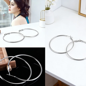 Detailed view of oversized polished silver hoop earrings with classic clasp closure
