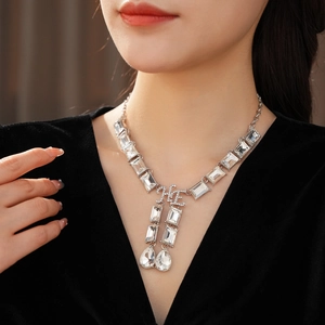 Detail of luxury necklace with rectangular and teardrop crystals worn by a model