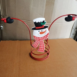 Detailed view of snowman holiday wine glass holder with metal coils and plaid scarf accent