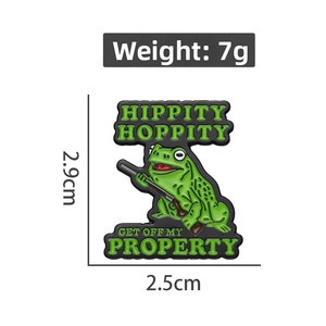 Detail view of cartoon frog enamel pin showing dimensions 2.9cm height and 2.5cm width
