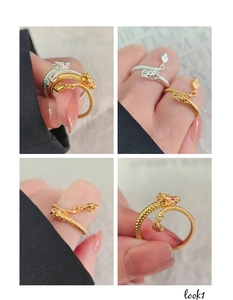 Detailed views of gold and silver dragon open rings with red accents and scale textures