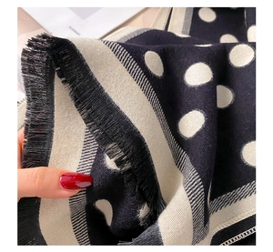 Detail of double-sided polka dot and striped scarf with elegant long fringe tassels