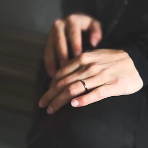 Close-up of minimalist silver band ring worn on hand with polished mirror finish