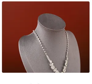 Macro detail of a sparkling silver rhinestone necklace displayed on a mannequin stand