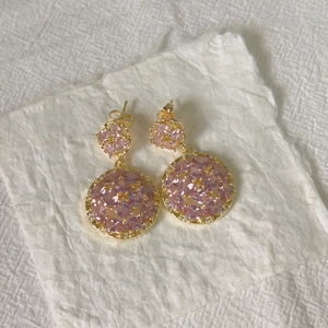 Macro view of double-layered round pink marquise zircon earrings in gold setting