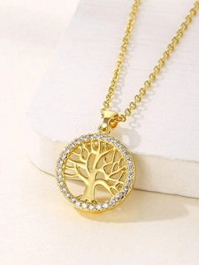 Detailed close-up of golden Tree of Life pendant with sparkling crystals on white stone
