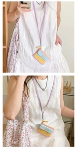 Detail of macaron multi-color card holder pouch with purple neck strap worn by a model