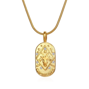 Macro shot of gold Capricorn oval pendant with zircon stones and snake chain detail