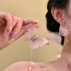 Close-up detail of sweet pink butterfly tassel earrings featuring delicate mesh wings and crystals