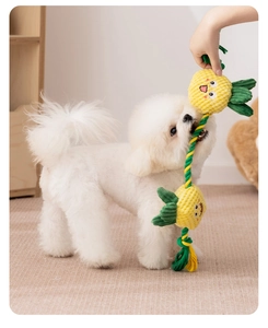 Interactive pineapple rope toy for dogs showing a puppy playing tug-of-war at home