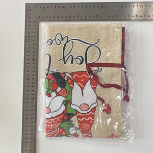 Detail of Christmas linen gift bag with festive gnome print and Joy lettering