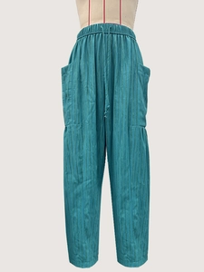 Detailed view of teal striped casual pants with drawstring waist and large side pockets