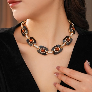 Vintage necklace with amber gems and rhinestones on black enamel links worn by a model