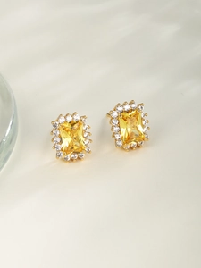 Detail view of gold-plated square yellow gemstone earrings with white zircon accents