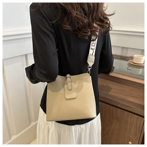 Detail of beige PU leather bucket bag featuring a trendy geometric print wide shoulder strap