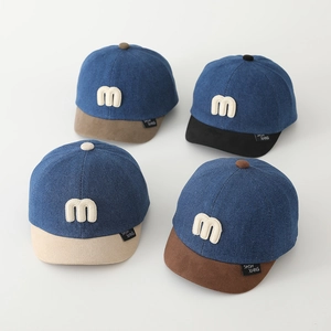 Dettaglio dei cappellini da baseball in denim per bambini con logo M ricamato a contrasto