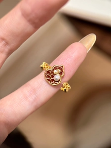 Makro-Detail des roten Emaille-Kalebasse-Rings mit Perle und Ginkgoblatt-Dekor