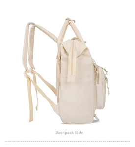 Side view of beige nylon mommy diaper backpack featuring adjustable straps and pockets