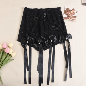 Détail d'un short en dentelle noire avec des nœuds en satin et des strass étincelants