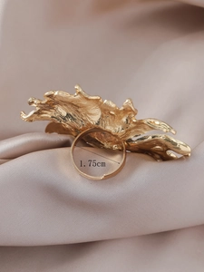 Detail view of large gold sunflower ring with molten lava texture and adjustable opening
