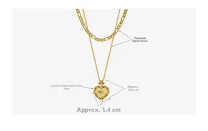 Détail d'un collier double épaisseur doré avec pendentif cœur et zircone