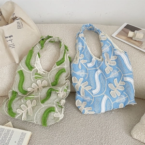 Détails de broderie de fleurs en dentelle et franges sur sacs en toile vert et bleu