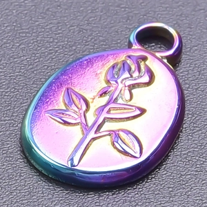 Macro shot of an iridescent stainless steel oval pendant featuring a 3D rose flower relief