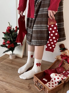 Close-up of thick festive Christmas socks featuring cute apple patterns and holiday packaging