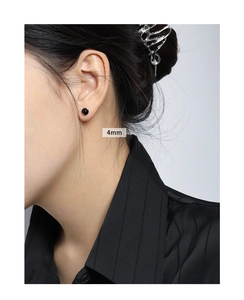 Close-up of 4mm black agate stud earrings showing size and fit on a model's ear