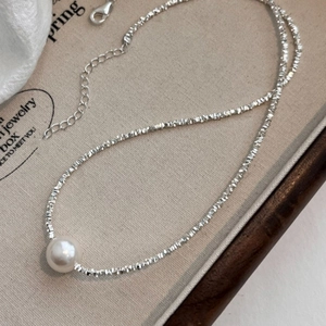 Detail of S925 silver necklace with white pearl pendant in a wooden jewelry box