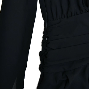 Detail of invisible zipper and pleated chiffon fabric on the black V-neck mini dress