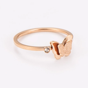 Detail of rose gold butterfly ring with frosted wings and sparkling zircon stone