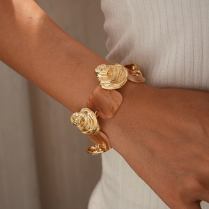 Close-up of vintage resin square links and golden swirl metal bracelet on a model's wrist
