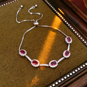 Detail eines verstellbaren Bolo-Armbands mit fünf ovalen roten Edelsteinen und Zirkon-Halo