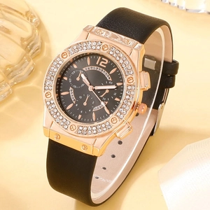 Close-up of elegant rose gold watch with rhinestone bezel and black leather strap