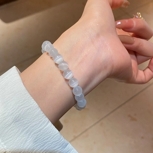 Close-up of cat eye stone beaded bracelet showing unique light reflection on model's wrist