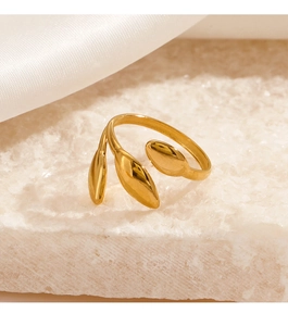 Detail of 18K gold plated leaf ring on white stone base with soft silk background