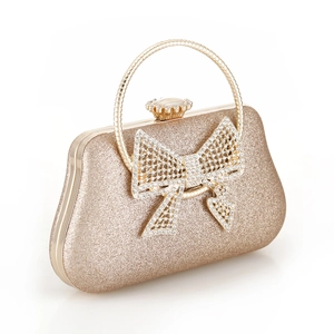 Close-up of golden evening clutch featuring a sparkling surface and crystal bow knot detail