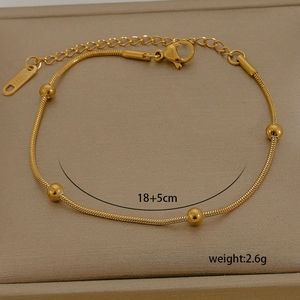 Detail of 18K gold-plated stainless steel snake chain bracelet with polished round beads
