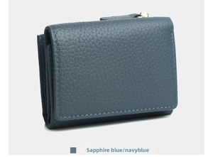 Macro shot of navy blue pebbled leather wallet with gold zipper and fine stitching
