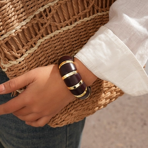 Detail of bohemian acrylic link bracelet with gold accents on a model's wrist