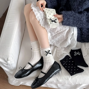 Détail de chaussettes japonaises avec nœuds décoratifs et motifs en dentelle à pois