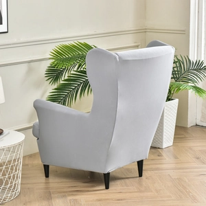 Elastic light gray wingback chair cover fully wrapping a single armchair in a modern room